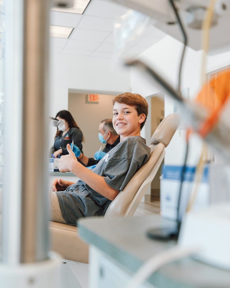 Young patient giving a thumbs up in the chair